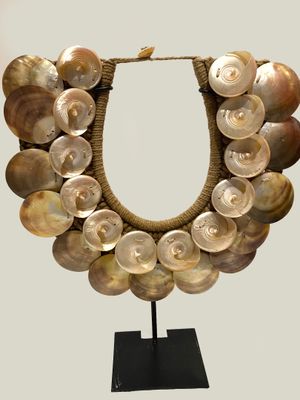 an image of a necklace made out of shells on a stand