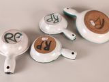 three teapots with numbers on them on a table