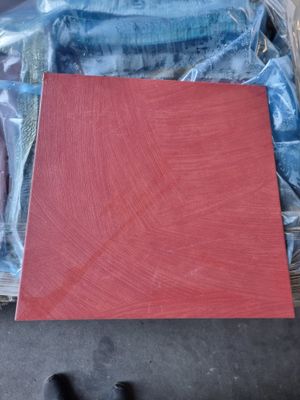 un morceau de bois rouge posé au sommet d'un tas de plastique