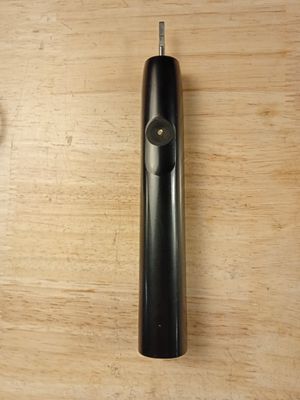 une brosse à dents noire posée sur une table en bois
