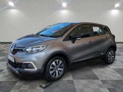 a grey car is parked on a checkered floor in a garage