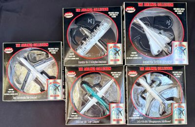 Quatre boîtes de figurines Star Wars sont posées sur une surface noire