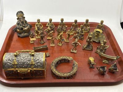 brass figurines on a red tray with a white background