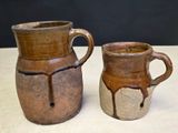two brown vases sitting next to each other on a table