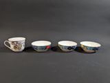 four coffee cups are lined up in a row on a table