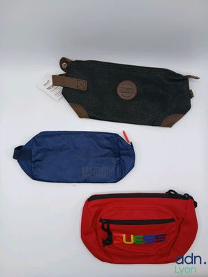 three fanny bags are lined up in a row on a white surface