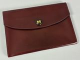 portefeuille en cuir marron avec un fermoir doré sur le devant