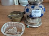 un vase bleu et blanc posé sur une table, à côté d'une assiette en verre