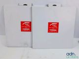 two white boxes with red stickers on them sitting on a table