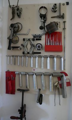 Il y a de nombreux outils accrochés au mur dans ce garage.
