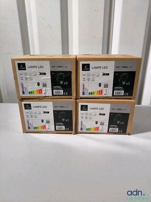 quatre boîtes de cartouches d'encre posées sur une table blanche