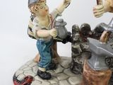 a figurine of a man and a woman working on a piece of metal