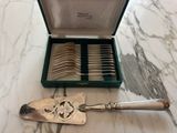 a silverware set in a green case on a marble table