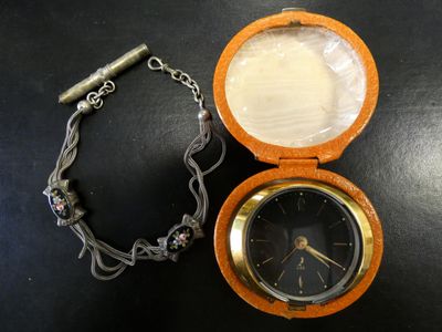 une montre de poche attachée à une chaîne, posée sur une table