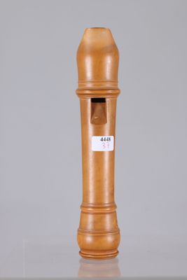a wooden pepper mill on a table with a label on it