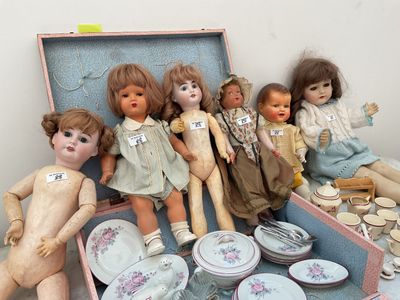 a bunch of dolls that are sitting in a suitcase