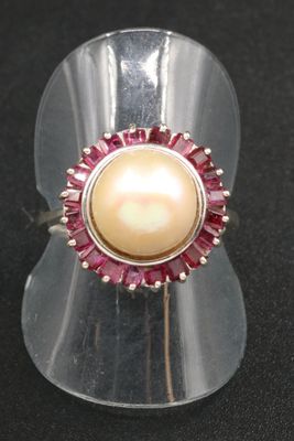 pink and white pearl ring on clear acrylic stand