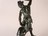 bronze statue of a man holding a knife in his right hand