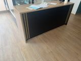 a black and gold desk in an office with a large window