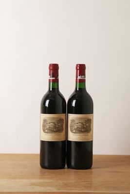 deux bouteilles de vin posées l'une à côté de l'autre sur une table en bois