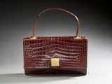 a brown crocodile skin purse with a gold clasp