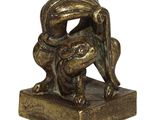 statue en bronze représentant une grenouille posée sur un socle, sur fond blanc