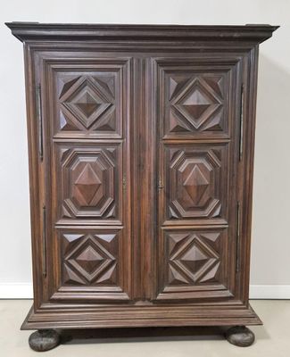 an antique wooden armoire with carved panels on top of it