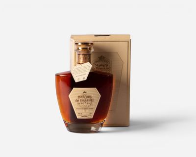a bottle of whisky sitting next to a cardboard box on a white surface