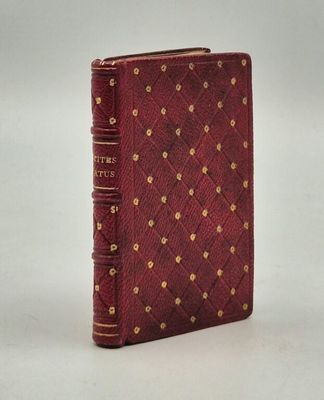 un vieux livre à la couverture rouge ornée de clous dorés