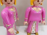two figurines of a couple dressed in pink and gold