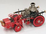 un camion de pompiers miniature posé sur une surface blanche