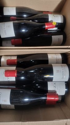 several bottles of wine are in a cardboard box on a table