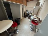 a room with a table, chairs, and a refrigerator in it