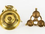 two brass bells sitting next to each other on a white surface