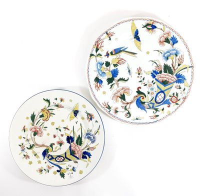 two plates with designs of birds and flowers on them on a white surface