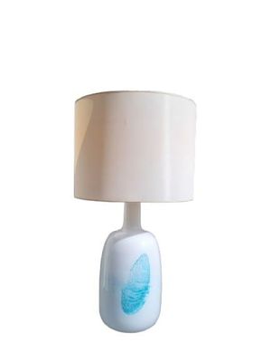 une lampe de table blanche ornée d'un motif bleu