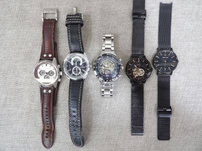 several different watches are lined up on a table