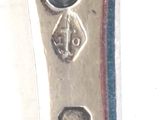 a close up of a silver spoon with a coin on it