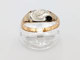 une photo d'une bague en or et en argent posée sur une surface transparente