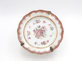 une assiette ornée d'un motif floral sur une surface blanche
