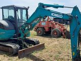 a small excavator that is sitting in the grass