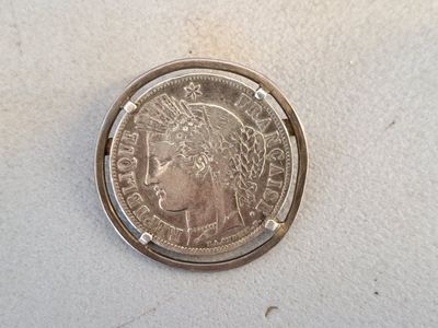 a close up of a silver coin with a woman ' s head on it