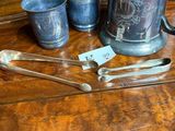 a wooden table topped with silverware and silver spoons