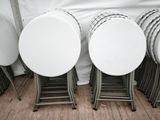 de nombreuses tables et chaises blanches dans une pièce ornée d'un rideau blanc