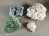 three different colored crystals on a table with a white background