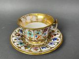 a close up of a cup and saucer on a table