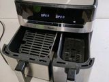 a silver and black air fryer sitting on a counter