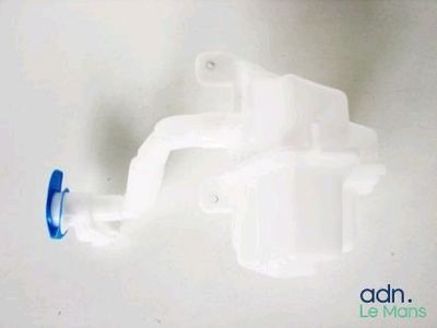 un gros plan d'un objet en plastique muni d'une poignée bleue, posé sur une surface blanche