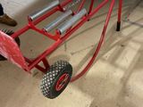 a small red cart with two wheels in a garage