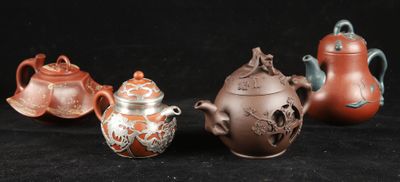 four different types of teapots are lined up on a black surface